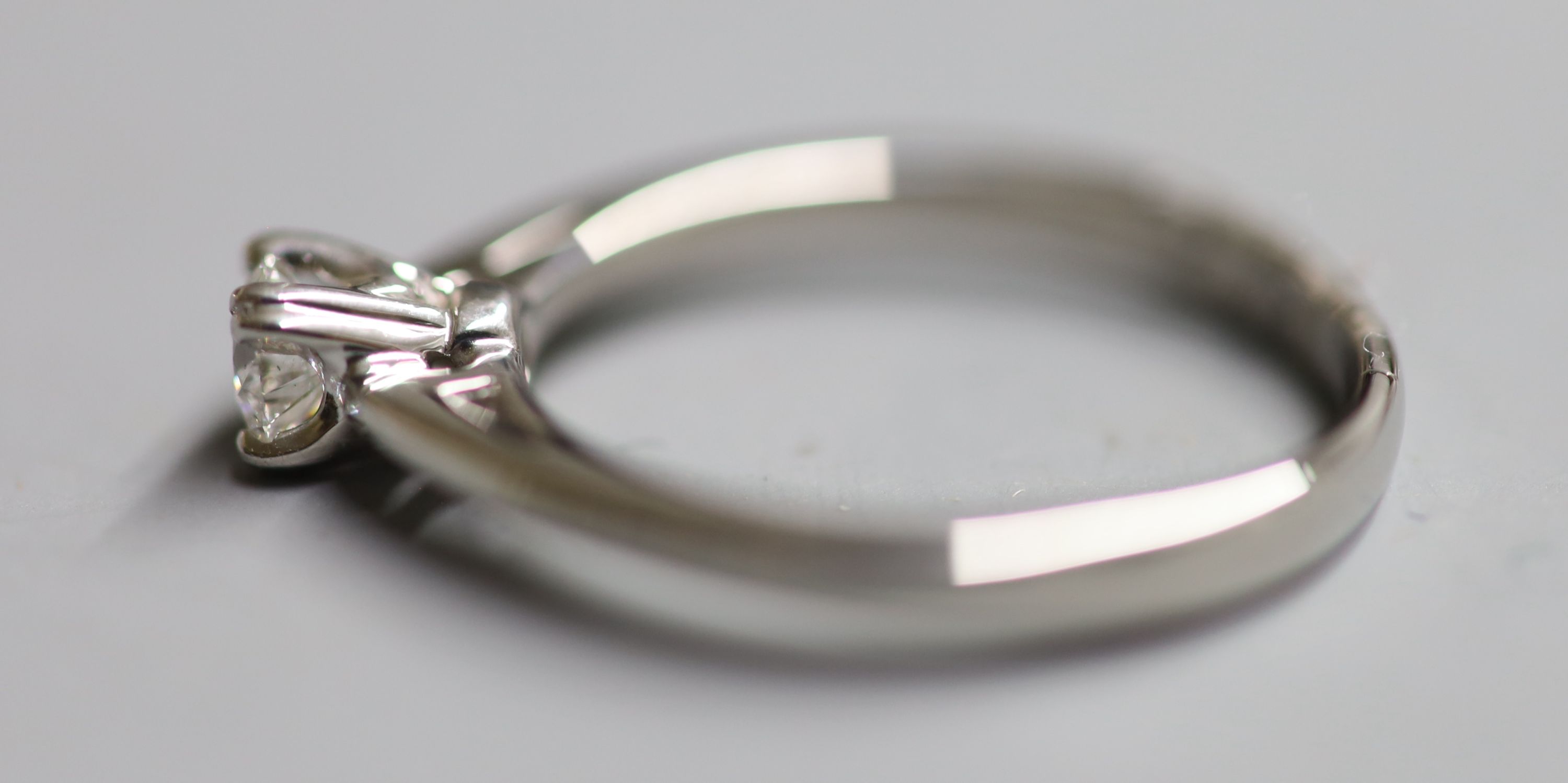 A modern white metal (stamped Plat) and solitaire diamond ring, size N, gross 4 grams,